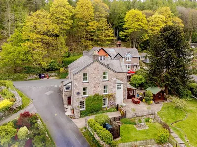 an aerial view of a large stone house with a driveway at 1 Bed in Eskdale SZ503 in Beckfoot