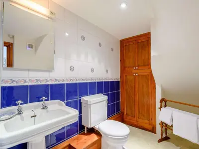 a blue and white bathroom with a toilet and a sink at 1 Bed in Eskdale SZ503 in Beckfoot
