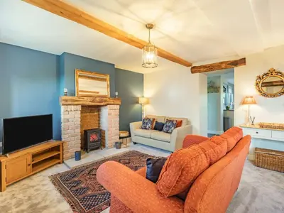a living room with two chairs and a fireplace at 3 Bed in Bridekirk 85717 in Bridekirk