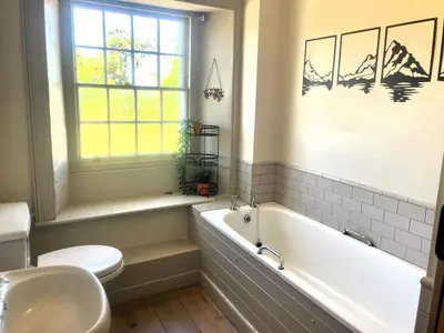 a bathroom with a tub and a toilet and a sink at 2 Bed in High Lorton 86023 in Lorton