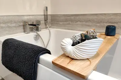 a bath tub with a white bowl on a cutting board at Cranford House in Keswick
