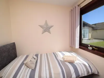 a bedroom with a bed with a star on the wall at 2 Bed in Isle of Whithorn 77880 in Isle of Whithorn
