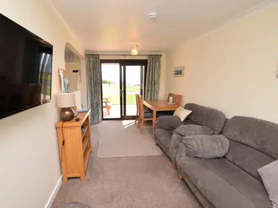 a living room with a couch and a table at 2 Bed in Isle of Whithorn 77880 in Isle of Whithorn