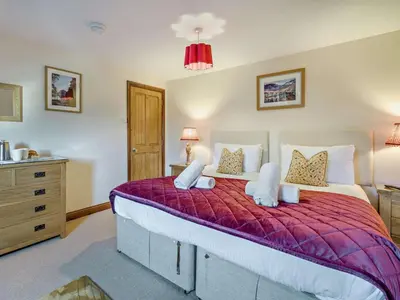 a bedroom with a large bed with a red comforter at 5 Bed in Cleator oc-sz529 in Ennerdale Bridge