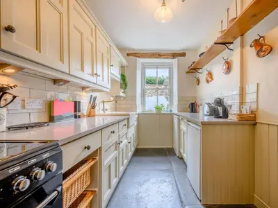a large kitchen with white cabinets and a window at 3 Bed in Ennerdale Bridge SZ392 in Ennerdale Bridge