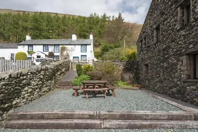 a picnic table in front of a stone building at 3 Bed in Threlkeld SZ433 in Threlkeld