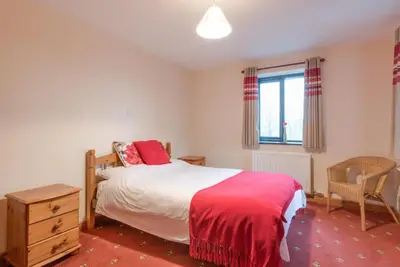 a bedroom with a bed and a chair and a window at 3 Bed in Threlkeld SZ433 in Threlkeld