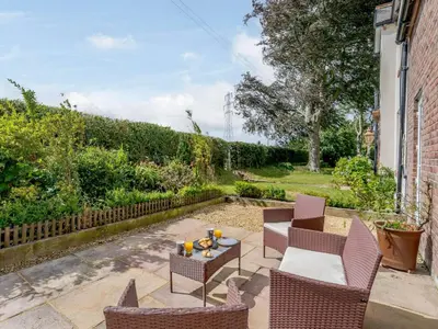 a patio with chairs and a table in a yard at 1 Bed in Grinsdale Bridge 85163 in Carlisle