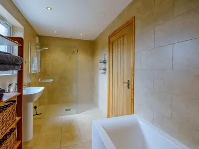 a bathroom with a tub and a shower and a sink at 1 Bed in Grinsdale Bridge 85163 in Carlisle