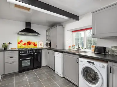 a kitchen with white cabinets and a washer and dryer at 2 Bed in Mawbray SZ214 in Mawbray