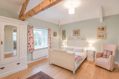 a bedroom with a white bed and a chair at 2 Bed in Boltongate SZ396 in Mealsgate
