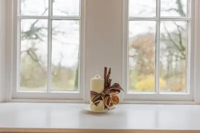 a candle sitting on a table in front of a window at 2 Bed in Boltongate SZ396 in Mealsgate