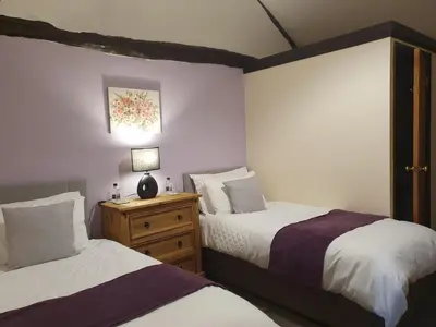a bedroom with two beds and a lamp on a night stand at The Herdwick Inn in Penruddock