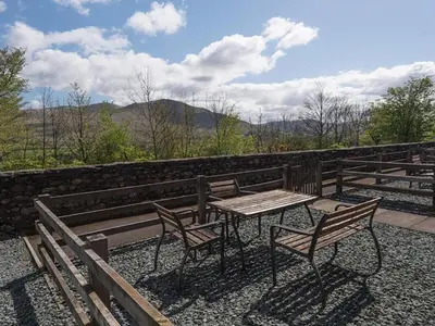 a table and two chairs sitting next to a fence at 3 Bed in Threlkeld SZ083 in Threlkeld