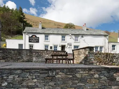 a white building with a bench in front of it at 3 Bed in Threlkeld SZ083 in Threlkeld