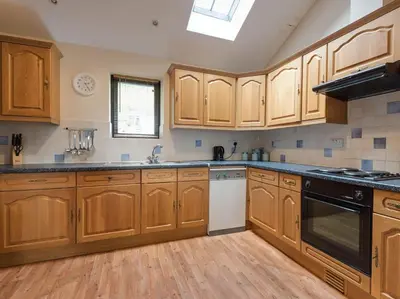 a kitchen with wooden cabinets and black appliances at 3 Bed in Threlkeld SZ083 in Threlkeld