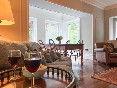 a living room with a couch and a table with wine glasses at Daweswood, Patterdale, characterful with fairy tale garden and fell walks from the door in Patterdale