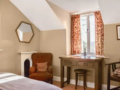 a bedroom with a desk and a chair and a window at Tarn Cottage in Grasmere