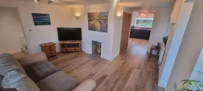 a living room with a couch and a flat screen tv at Cherry Croft in Wigton