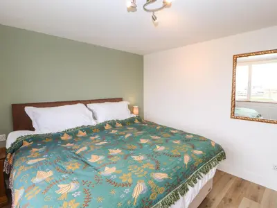 a bedroom with a bed and a mirror at Cherry Croft in Wigton