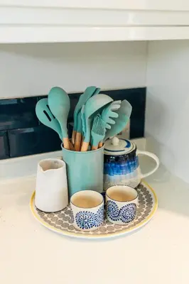 a tray with utensils and cups on a counter at High Tide Lodge in Gatehouse of Fleet