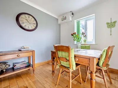 a dining room with a table and chairs and a clock at 4 Bed in Troutbeck nr Ullswater SZ256 in Troutbeck