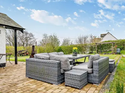 a patio with couches and a table in a yard at 4 Bed in Troutbeck nr Ullswater SZ256 in Troutbeck
