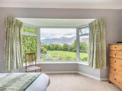 a bedroom with a large window and a chair at 3 Bed in Portinscale SZ528 in Portinscale