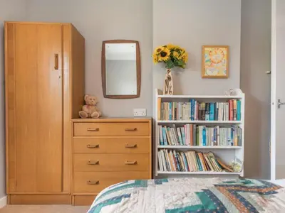 a bedroom with a book shelf and a dresser with a mirror at 3 Bed in Portinscale SZ528 in Portinscale