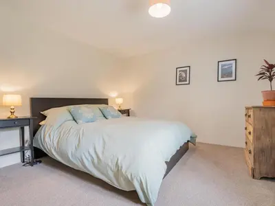 a bedroom with a bed and a dresser with two lamps at 3 Bed in Seathwaite SZ107 in Eskdale