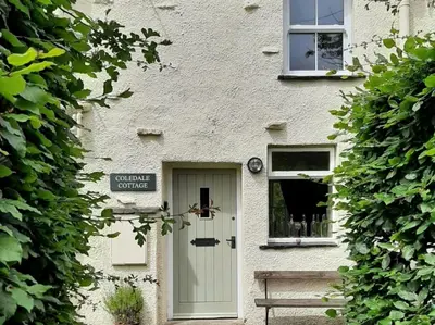 a white building with a door and a bench in front at 1 bed property in Keswick 86117 in Braithwaite
