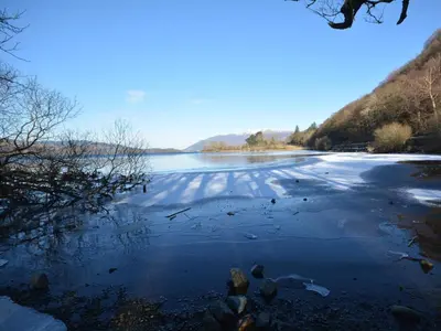a body of water with birds standing on the ice at 2 Bed in Rosthwaite 86397 in Rosthwaite