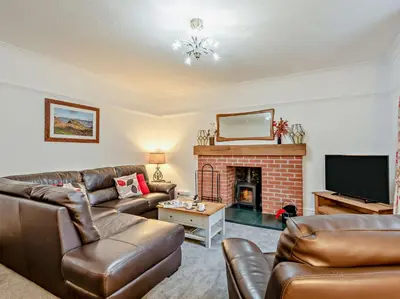 a living room with leather furniture and a fireplace at 2 Bed in Rosthwaite 86397 in Rosthwaite