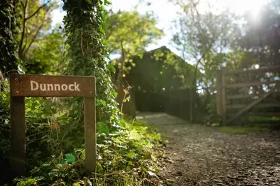 a sign on a dirt trail in the woods at Dunnock Lodge with Hot-tub in Carlisle