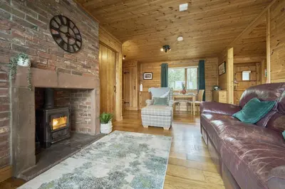 a living room with a couch and a fireplace at Fieldfare Lodge with Hot-tub in Carlisle
