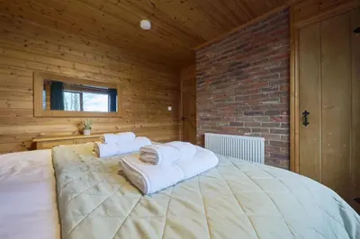 a bedroom with a large bed with towels on it at Fieldfare Lodge with Hot-tub in Carlisle