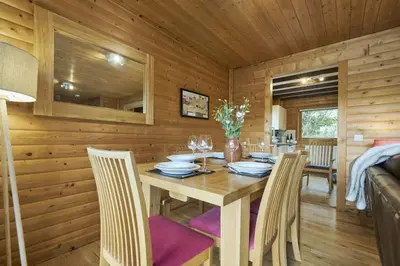 a wooden dining room with a table and chairs at Heron Lodge with Hot-tub in Carlisle