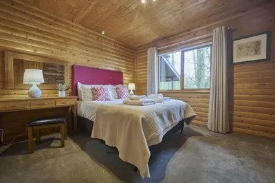 a bedroom with a bed and a desk and a window at Heron Lodge with Hot-tub in Carlisle