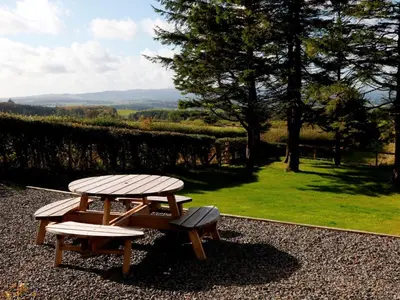 a picnic table and bench with a view of a park at 3 Bed in Lockerbie 89406 in Lockerbie