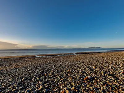 a pebble beach with the ocean in the background at 1 Bed in Allonby 28791 in Allonby