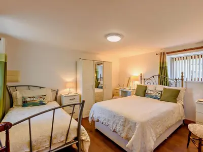 a bedroom with two beds and a mirror at 1 Bed in Allonby 28791 in Allonby