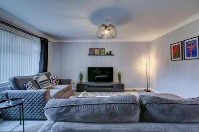 a living room with a couch and a tv at Ravenscroft - Coorie Doon in Irvine