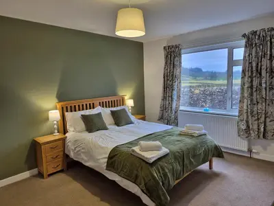 a bedroom with a bed and a large window at 3 Bed in Auldgirth 77430 in Auldgirth