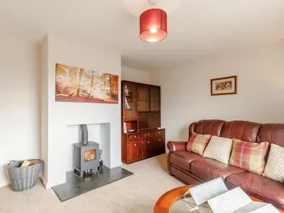 a living room with a couch and a wood stove at 3 Bed in Auldgirth 77430 in Auldgirth