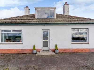 a white house with two windows and two potted plants at 3 Bed in Auldgirth 77430 in Auldgirth