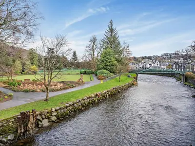 a river with a stone wall and a bridge at 2 Bed in Keswick 80515 in Keswick