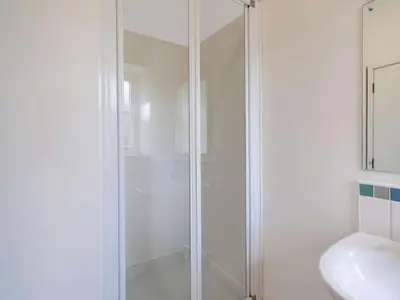 a white bathroom with a shower and a sink at 8 bed in Cockermouth 82453 in Bridekirk