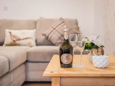a bottle of wine on a table with two wine glasses at 3 Bed in Threlkeld SZ217 in Threlkeld