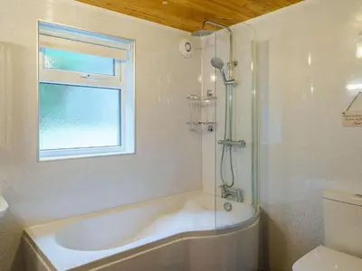 a bathroom with a bath tub and a window at 3 Bed in Threlkeld 86613 in Threlkeld