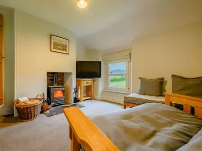 a bedroom with a bed and a fireplace and a tv at 2 Bed in Egremont 87227 in Egremont